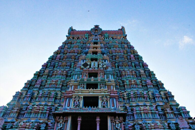 A stunning view of the intricately carved Sri Andal Temple Tower against a blue sky in Srivilliputhur, India.