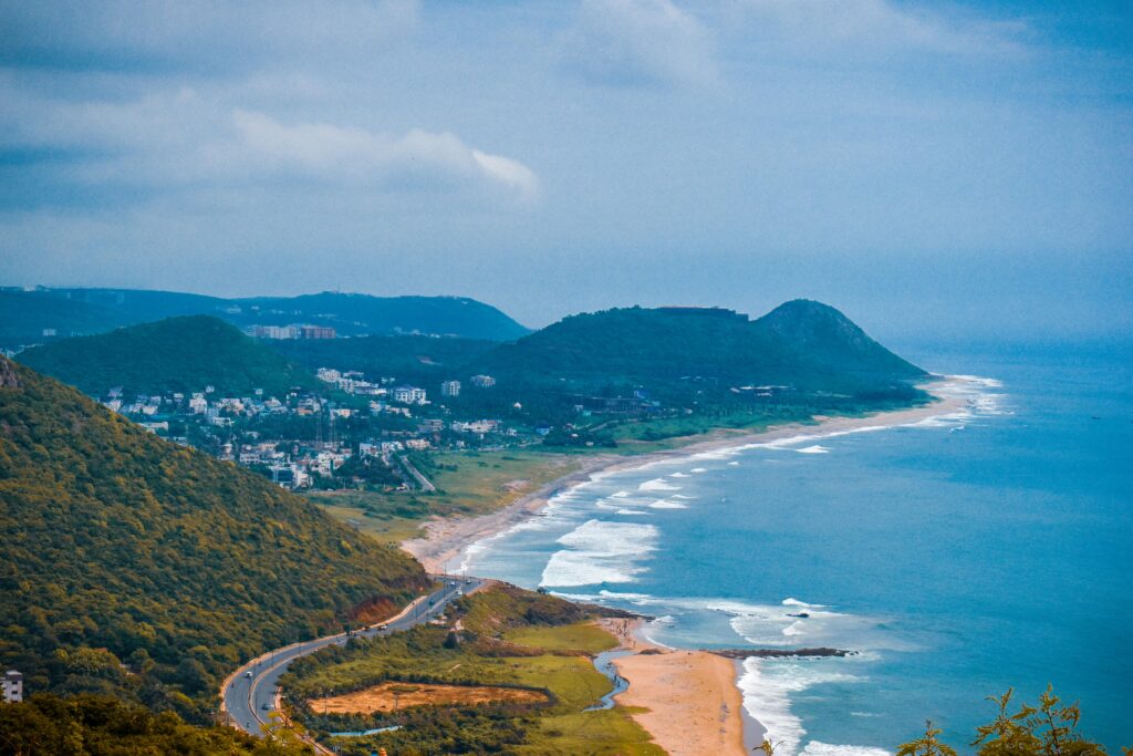 A breathtaking aerial view of the coastline in Visakhapatnam, capturing lush hills and the vibrant sea.